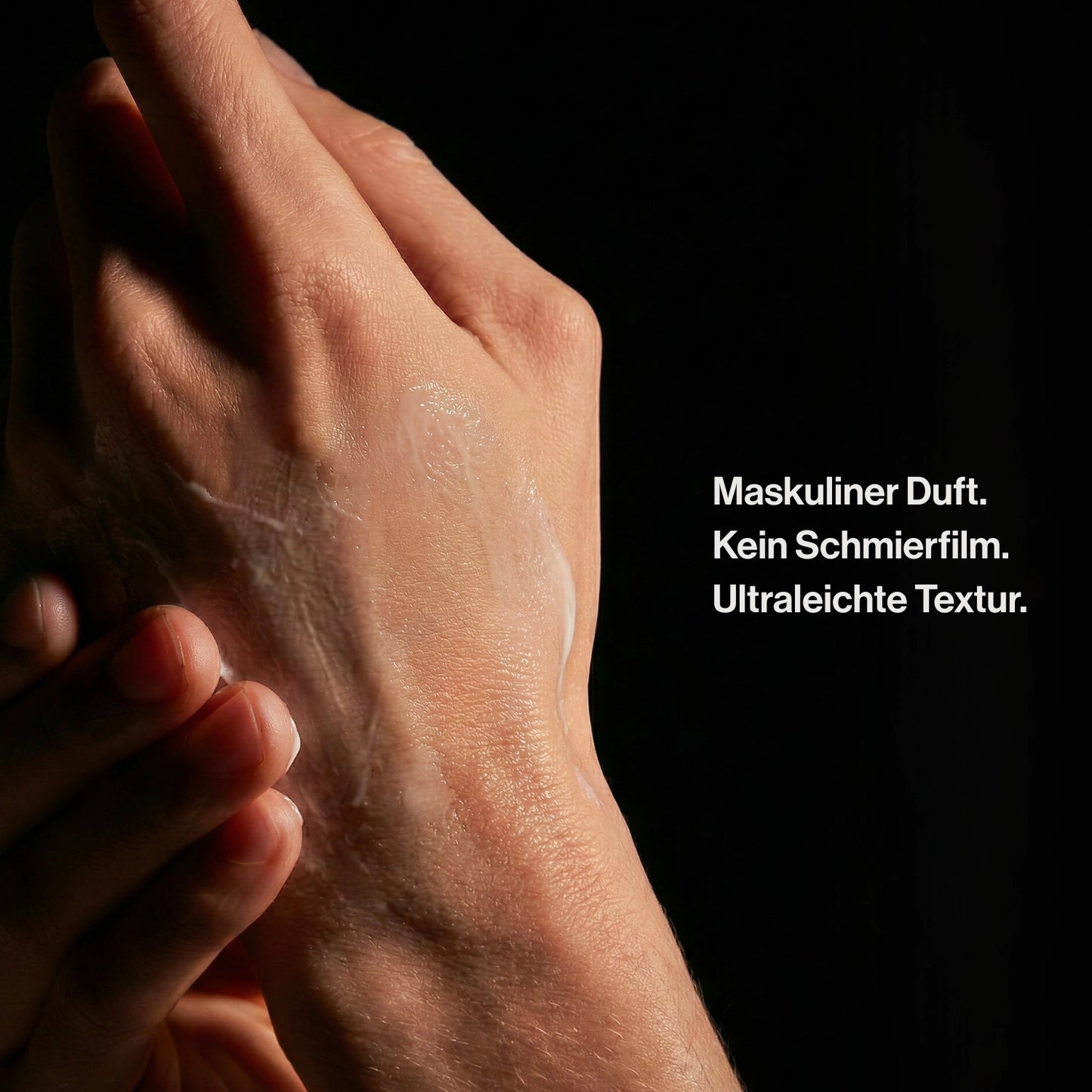 Handpflege für Männer mit ultraleichter Textur auf männlicher Haut im dunklen Studio-Setting
